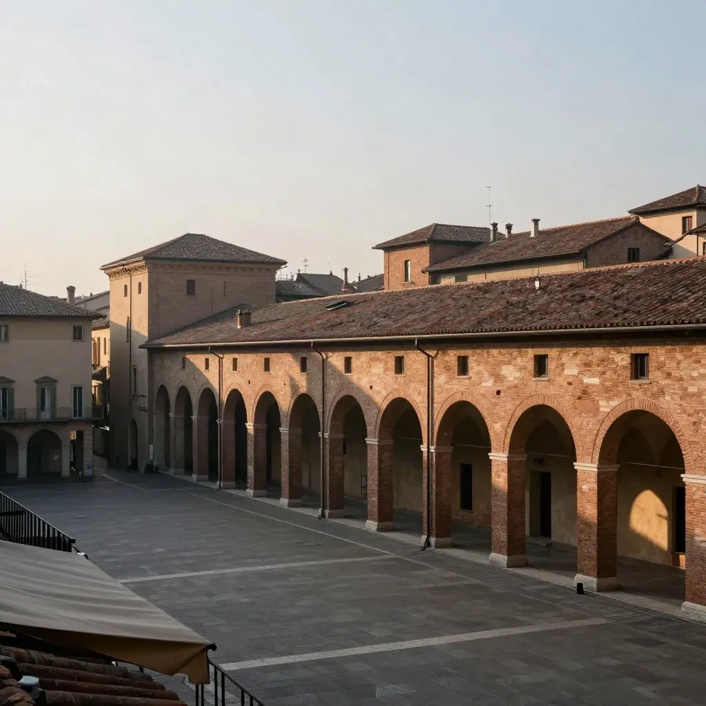 Portici di Bologna e tetti emiliani in luce calda, con fondo chiaro e atmosfera velata.
